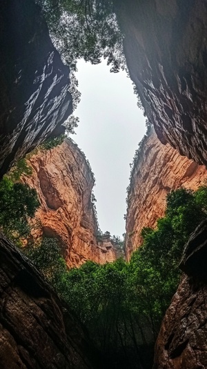 仰视视角，从峡谷中间望向天，天空正在下雨