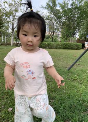 图中小女孩在草坪上跳舞
