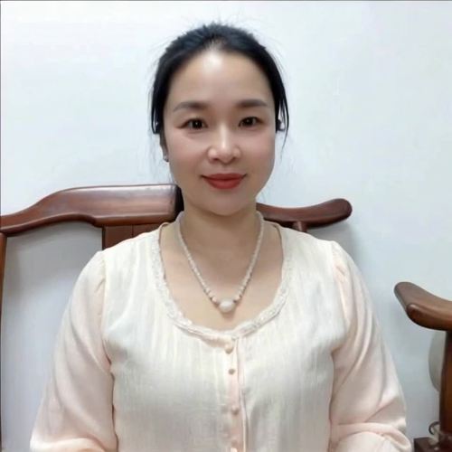 一位美丽的白衣女子坐在一朵莲花上,闭着眼睛,面带安详的微笑。她被金色的光芒包围着,散发着宁静和优雅的光环。