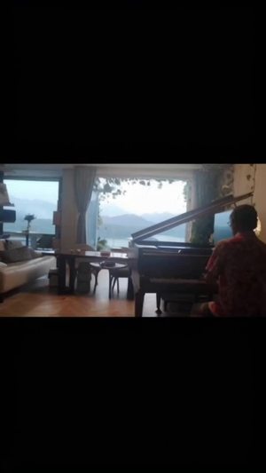 一位钢琴家在青山绿水的美景中弹琴